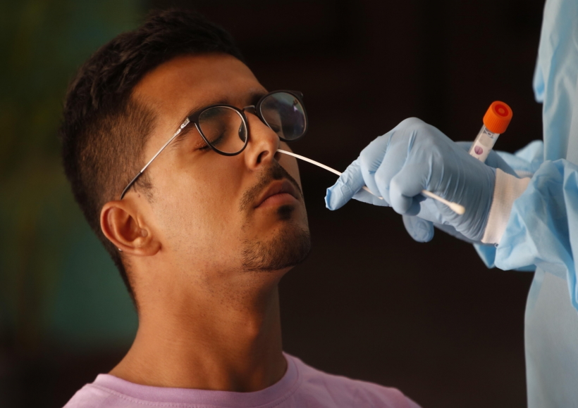 A health worker collects a nasal sample from a man for the RT-PCR test of Covid