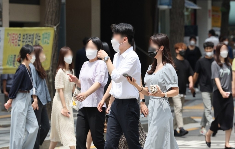 People walk along the street while voluntarily wearing masks in Seoul