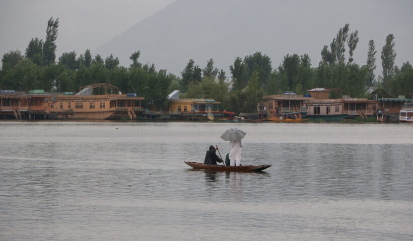 A man enjoys boat ride in the Dal Lake amidst rains in Srinagar