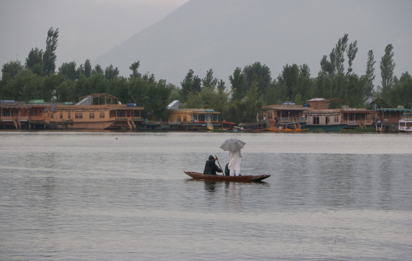 A man enjoys boat ride in the Dal Lake amidst rains in Srinagar