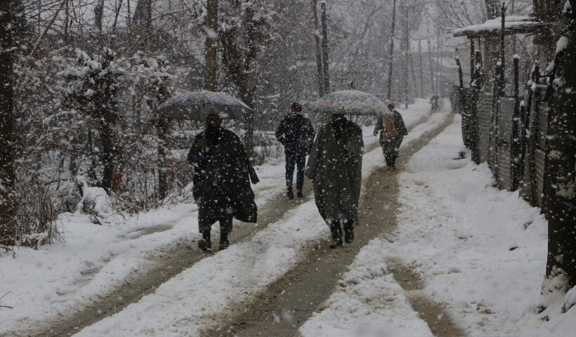 Srinagar: People shield themselves with umbrellas during heavy snowfall in Srinagar