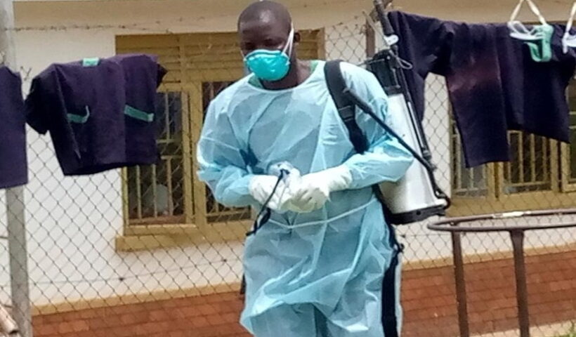 Medical workers perform disinfection for a demarcated Ebola treatment center at the Mubende Regional Hospital in Mubende District, Uganda,