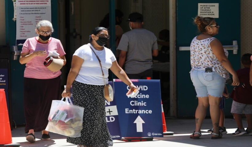 People wearing face masks are seen at a COVID-19 vaccine clinic in Los Angeles, California, the United States,
