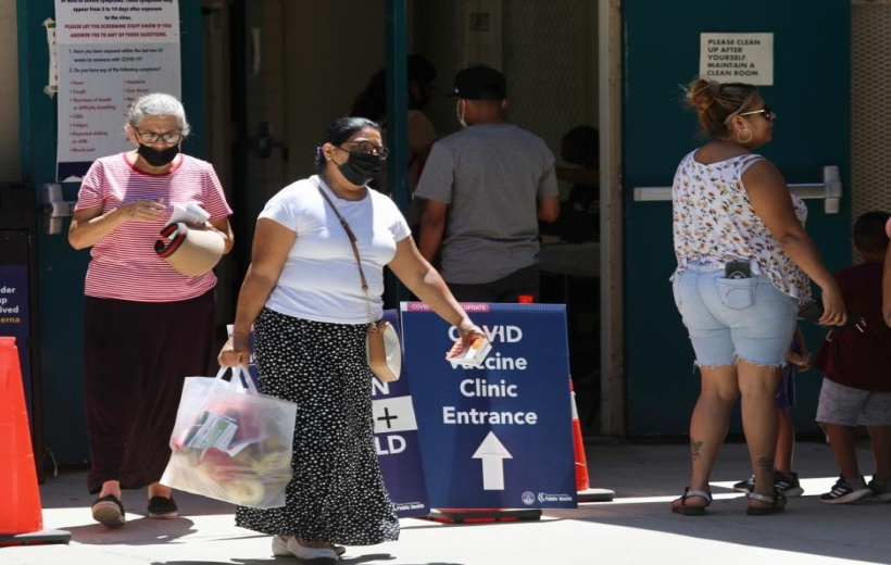 People wearing face masks are seen at a COVID-19 vaccine clinic in Los Angeles, California, the United States,