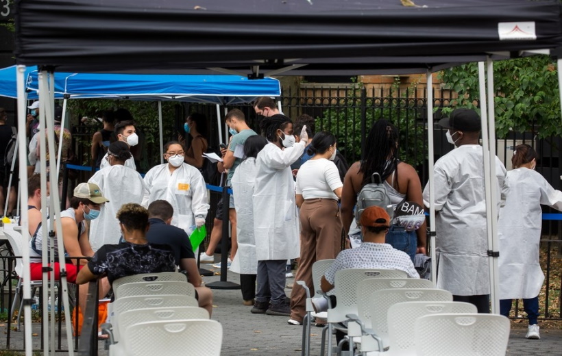 Health care workers assist people waiting to be vaccinated at a monkeypox vaccination site in New York,