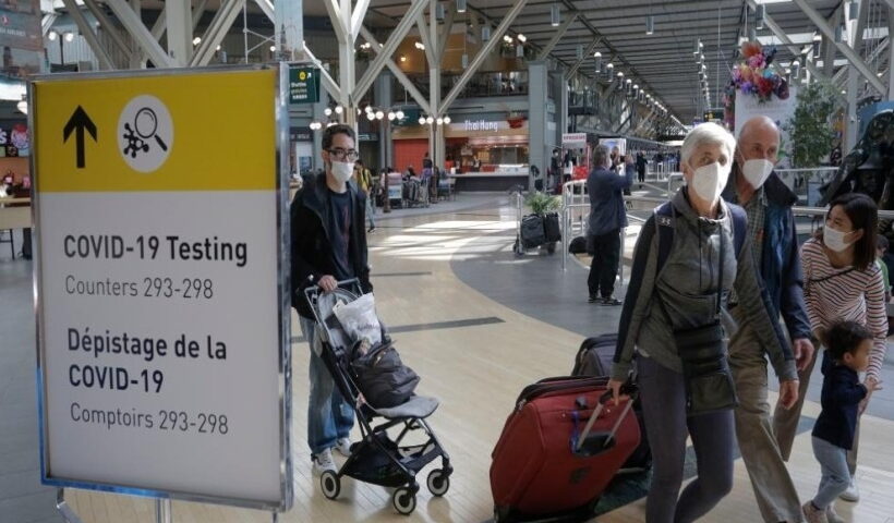 Travelers with face masks are seen at Vancouver International Airport in Richmond, Canada,