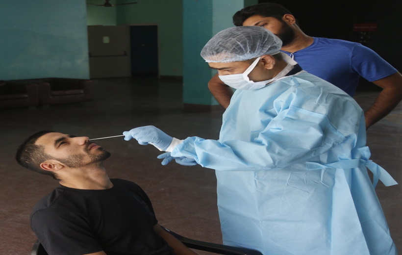 A health worker collects a nasal sample from a man for the RT-PCR test of Covid-19 at the hostel of Indira Gandhi Indoor stadium in New Delhi on
