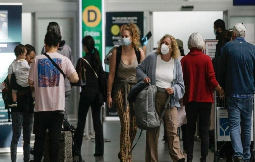 Travelers with face masks are seen at Vancouver International Airport in Richmond, Canada,
