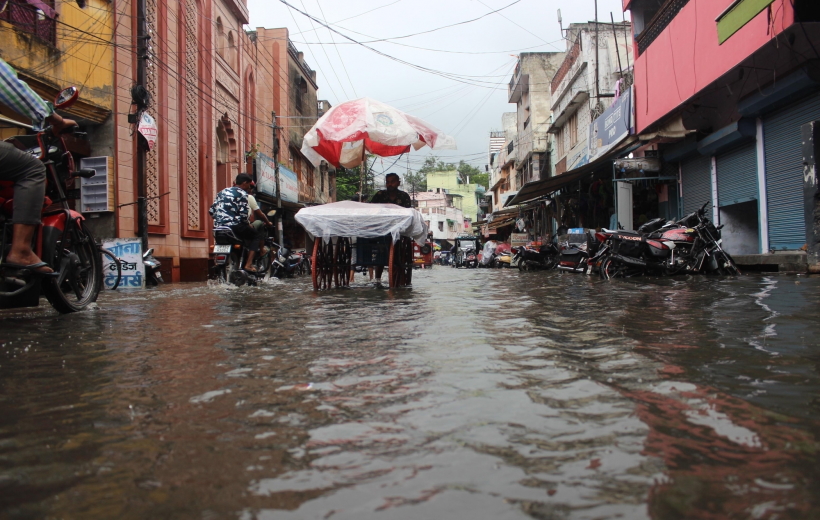 Meerut: Commuters wade through a waterlogged road during rain in Meerut