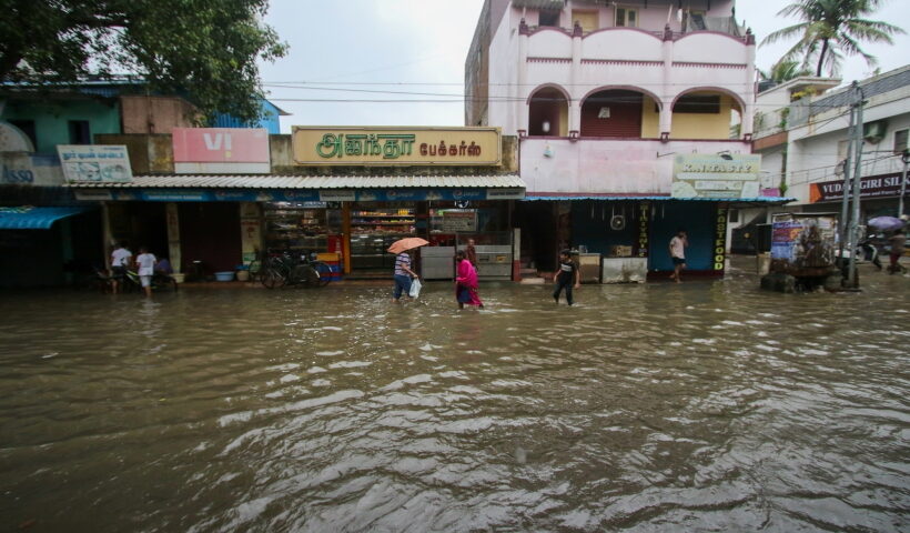 Chennai: People wade through a waterlogged road after heavy rain, in Chennai on Friday, Nov.