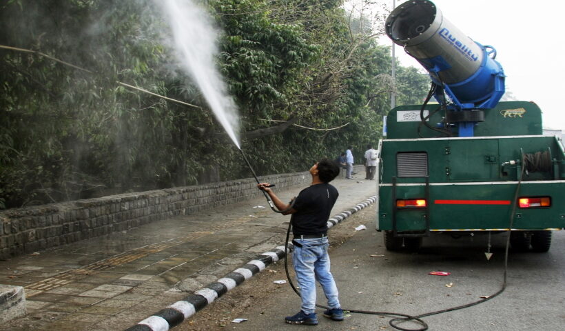 New Delhi: PWD worker sprays water sprinkle through a anti-smog gun to control pollution