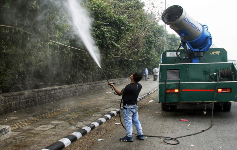 New Delhi: PWD worker sprays water sprinkle through a anti-smog gun to control pollution