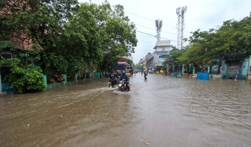 Chennai:Commuters wade through flooded road during heavy rains in Chennai on Tuesday