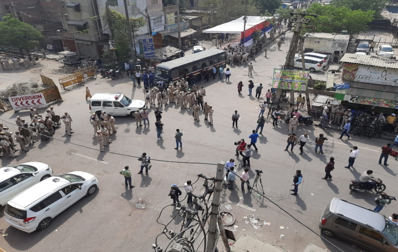 New Delhi : Security personnel stand guard near barricades, after clashes broke out between two communities during a Hanuman Jayanti processions on saturday, at Jahangirpuri in New delhi, on sunday