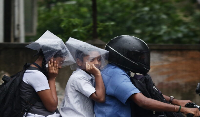 Chennai: School children shield themselves with plastic sheets during rains in Chennai