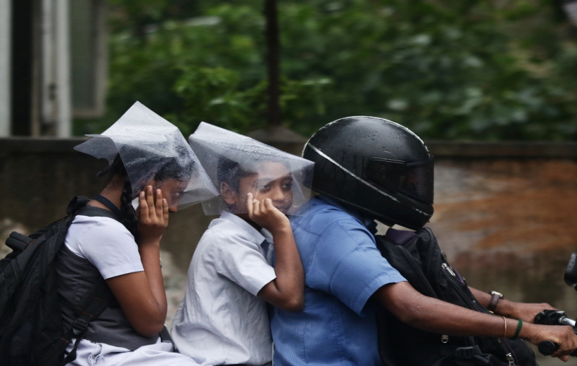 Chennai: School children shield themselves with plastic sheets during rains in Chennai