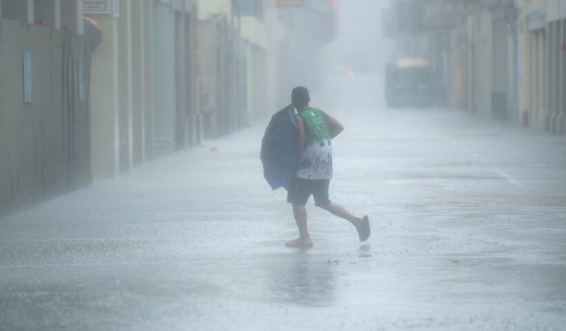 MACAO, Aug. 19, 2020 (Xinhua) -- A man walks in the rain on a road in Macao, south China, Aug. 19, 2020. China's Macao Special Administrative Region has downgraded its typhoon signal from highest No.10 level to No.8 on Wednesday at 7:30 a.m. local time, but the low-lying areas near the coastline were flooded, as Typhoon Higos had made landfall in the neighboring city of Zhuhai in the morning. Macao Meteorological and Geophysi