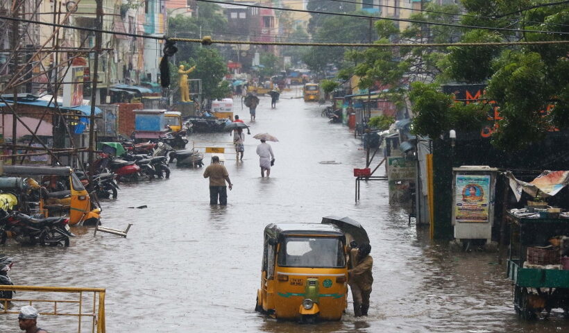 Chennai:Commuters wade through flooded road during heavy rains in Chennai on Tuesday