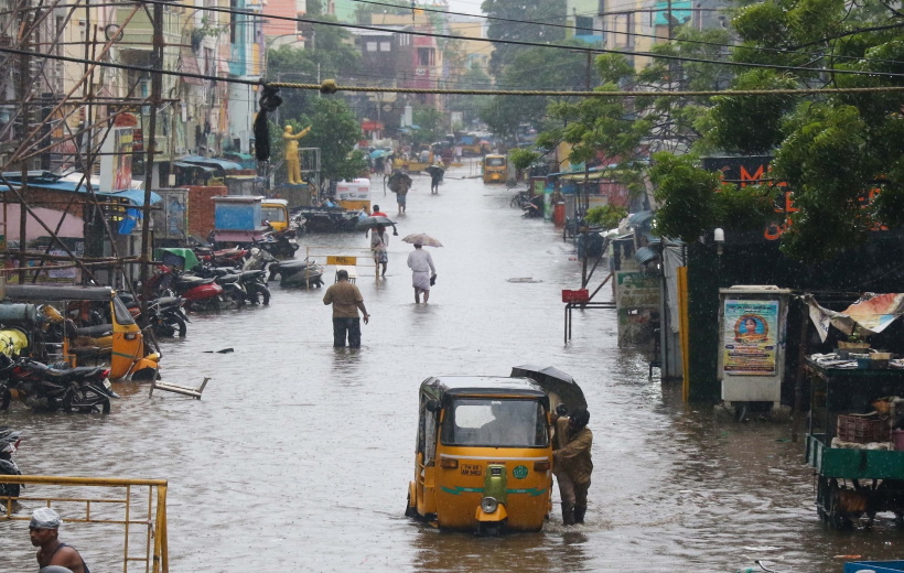 Chennai:Commuters wade through flooded road during heavy rains in Chennai on Tuesday