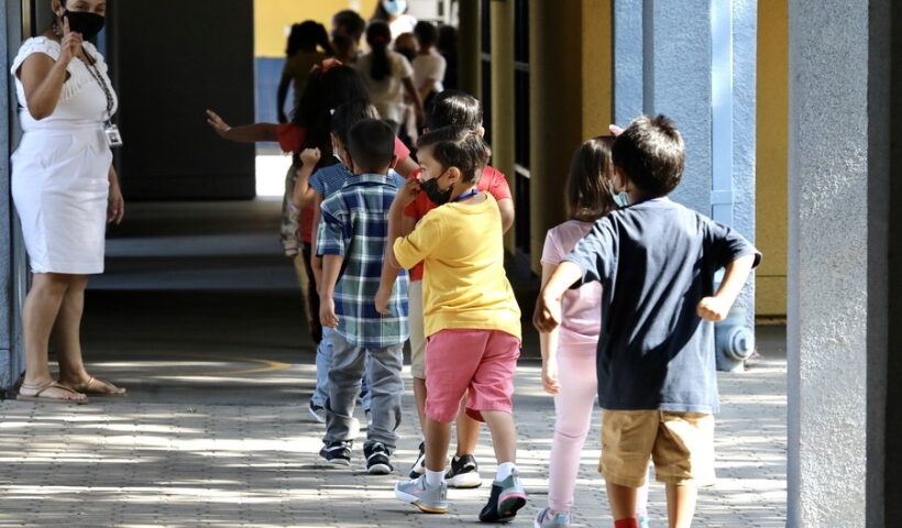 A teacher guides students to line up for their snacks at Montrara Ave. Elementary School in Lo