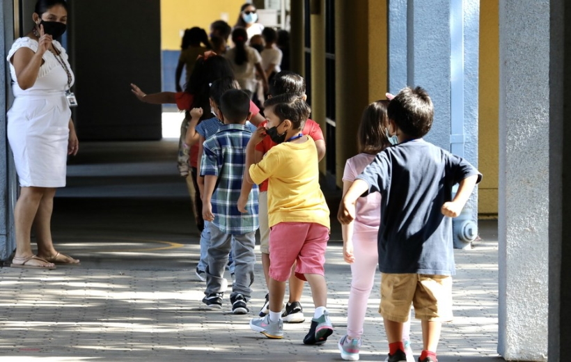 A teacher guides students to line up for their snacks at Montrara Ave. Elementary School in Lo