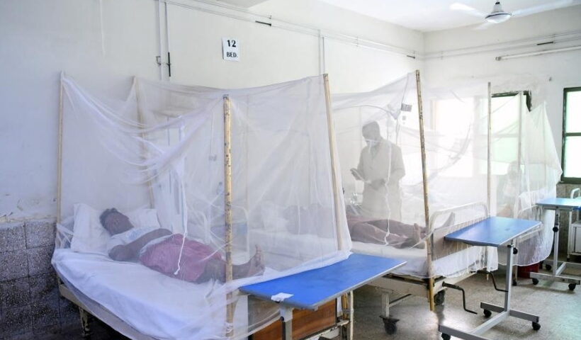 Patients affected with dengue fever are treated inside mosquito nets at a hospita