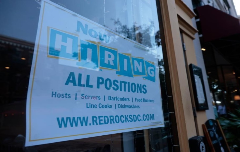 A hiring sign is posted on the window of a restaurant in the Old Town neighborhood of Alexandria