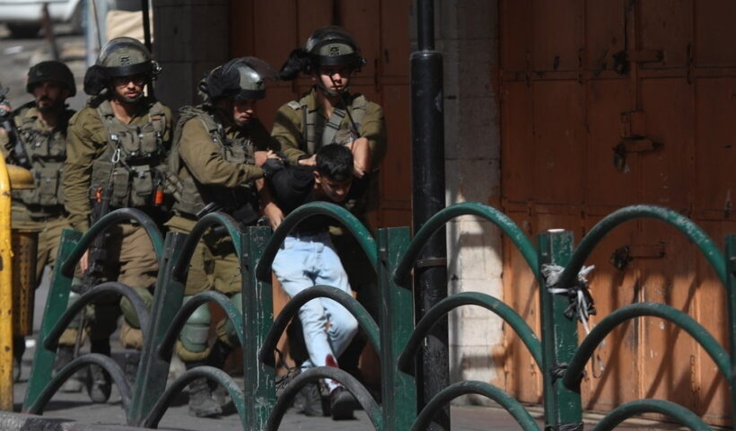 Israeli soldiers detain a Palestinian protester during clashes in the West Bank city of Hebron,