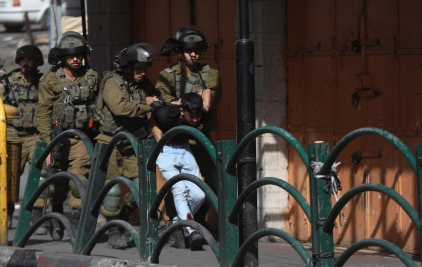 Israeli soldiers detain a Palestinian protester during clashes in the West Bank city of Hebron,