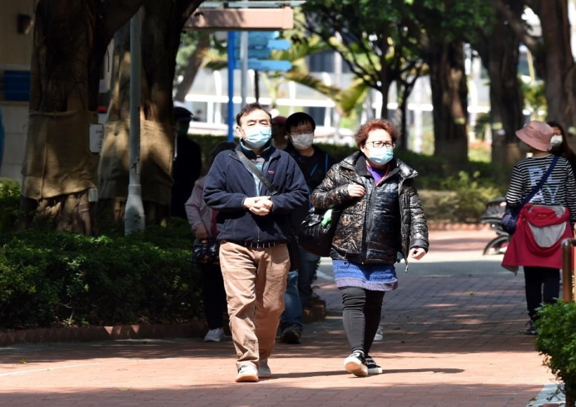 People wearing masks walk on road in Hong Kong
