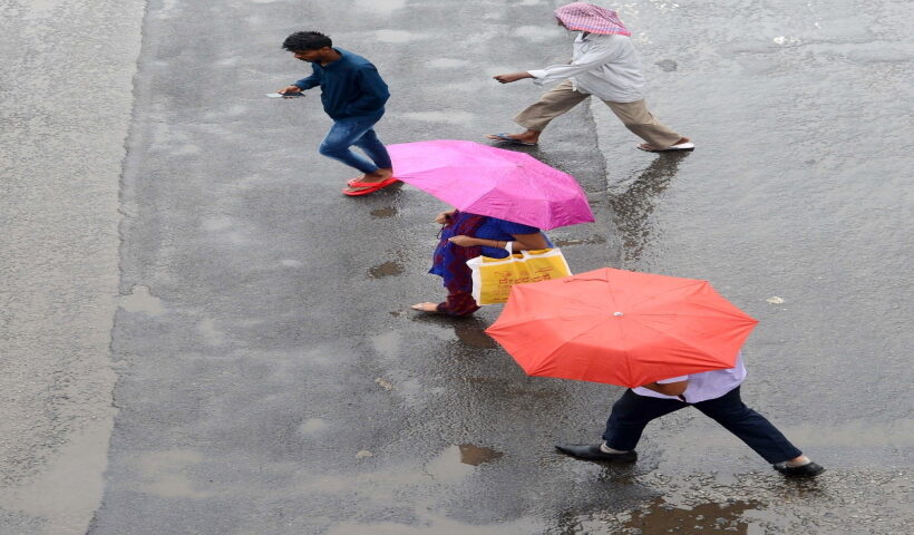 Bengaluru: People use umbrellas during light rainfall