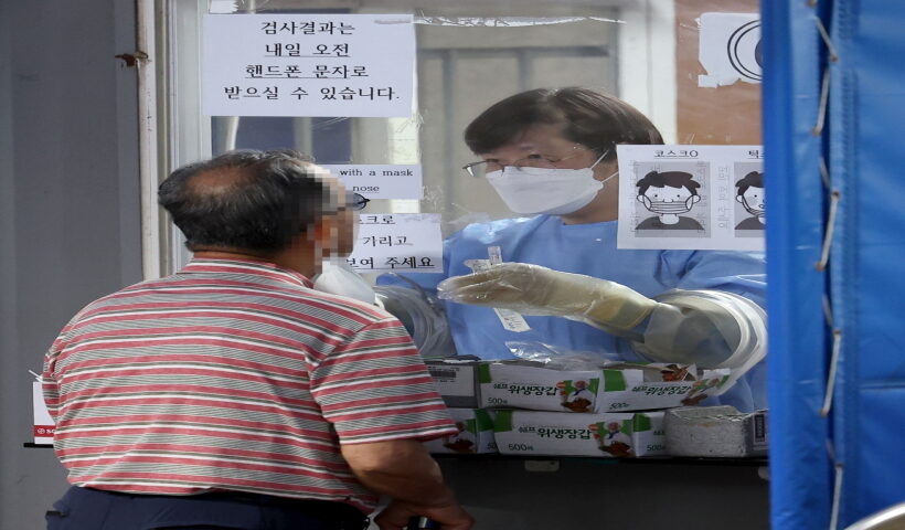 Seoul :A medical worker conducts a coronavirus test on a man at a screening clinic in Seoul's Gwanak Ward on