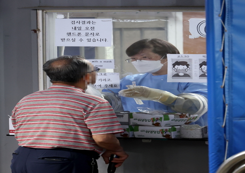 Seoul :A medical worker conducts a coronavirus test on a man at a screening clinic in Seoul's Gwanak Ward on