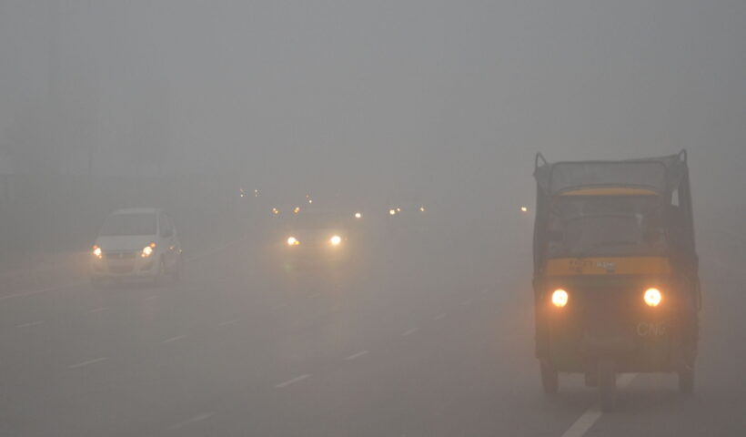 Gurugram: Vehicles move with their headlights on as fog cover reduces visibility in Gurugram on the chilly winter morning