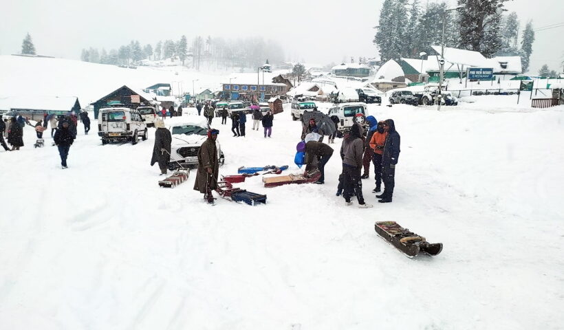 Gulmarg: Tourists at snow covered Gulmarg area during snowfall, in Baramulla district