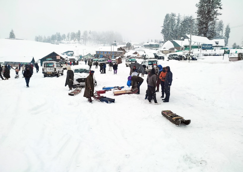 Gulmarg: Tourists at snow covered Gulmarg area during snowfall, in Baramulla district