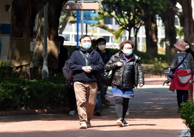 People wearing masks walk on road in Hong Kong,