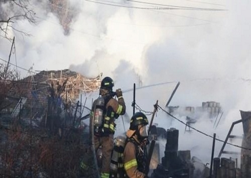 Firefighters battle a fire in the fourth district of Guryong Village, the last remaining slum in Seoul, in the capital's Gangnam Ward
