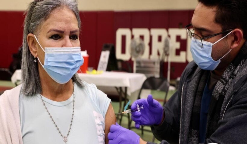 A health worker administers a flu vaccine shot to a local resident in Los Angeles, the United States