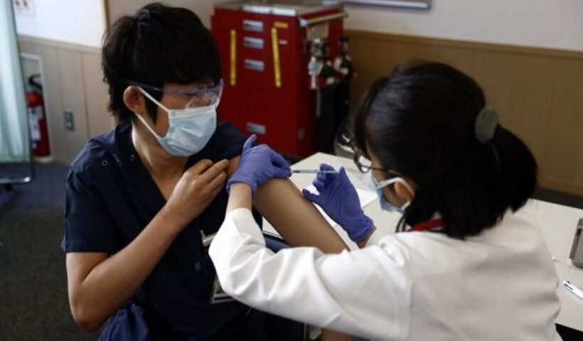 A medical worker receives a dose of the COVID-19 vaccine as the country launches its inoculation campaign at the Tokyo Medical