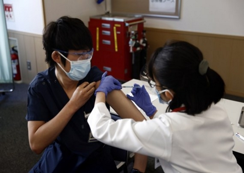 A medical worker receives a dose of the COVID-19 vaccine as the country launches its inoculation campaign at the Tokyo Medical Center in Tokyo