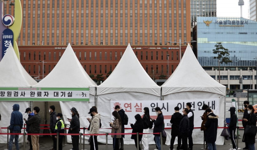 People stand in line to take coronavirus tests at a screening clinic in front of Seoul Station on March 31, 2022. South Korea's new daily COVID-19 cases fell more than 100,000 to around 320,000, but the number of seriously ill patients hit an all-time high amid the continued spread of the highly transmissible "stealth omicron" subvariant