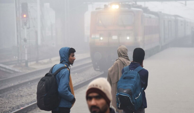 Patna: Passengers at a railway station on a cold foggy morning, in Patna,