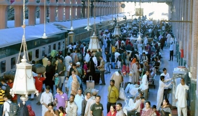 Passengers get on a train at a railway station ahead of the Islamic Eid al-Fitr festival in Lahore, Pakistan