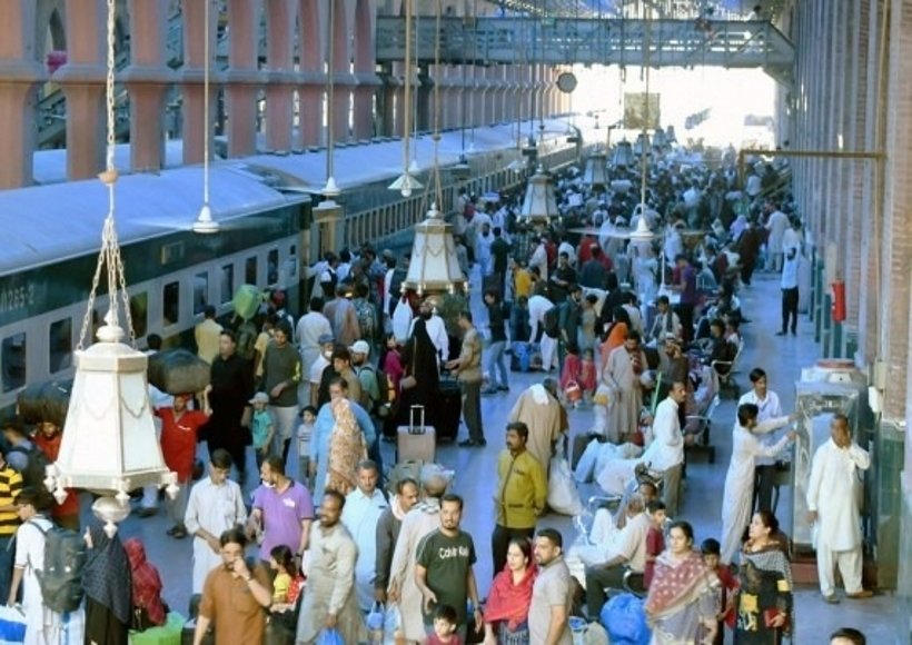 Passengers get on a train at a railway station ahead of the Islamic Eid al-Fitr festival in Lahore, Pakistan