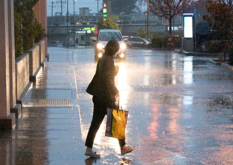 California: A pedestrian walks in storm in Millbrae, California, the United States, Jan. 4, 2023. A winter storm hit northern California, bringing rain and snow to the local area