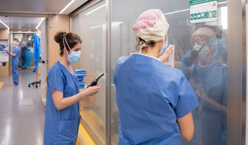 Medical workers communicate with colleagues inside a ward at a hospital in Barcelona, Spain,
