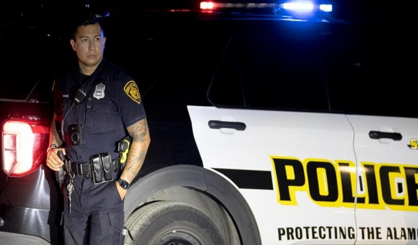 A police officer stands guard around the perimeter of the scene of an alleged human smuggling mass casualty event in San Antonio