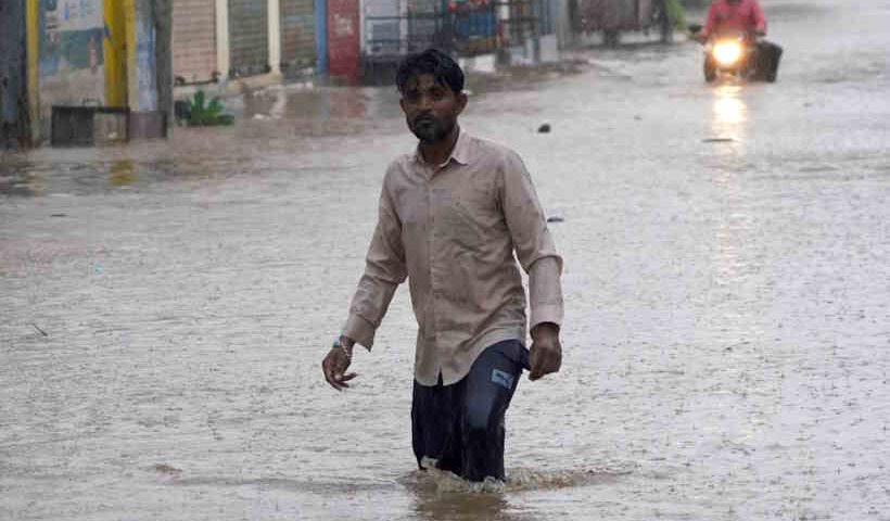 A man walks through a waterlogged road