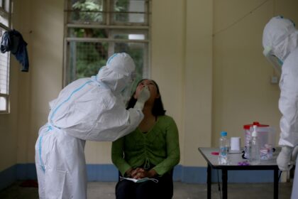 A health worker collects a sample for COVID-19 test